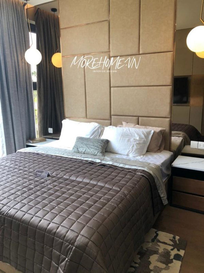 Những sản phẩm nội thất phòng ngủ chung cư do Morehome thực hiện, bao gồm giường ngủ với kiểu dáng đơn giản, bức tường đầu giường bọc da trần chỉ inox vàng, 2 bên ốp kính màu trà độc đáo , tab đầu giường bằng gỗ kết hợp mặt đá nhân tạo trắng vân mây nhỏ gọn hiện đại